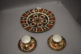 A Royal Crown Derby plate(1128) also two coffee cans and saucers(2451) in the Imari palette.