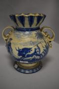 A 19th/20th century tin glazed twin handled vase having blue and white pattern and fluted neck.