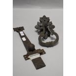 A large antique iron sliding door latch and a similar door handle having decorative escutcheon.