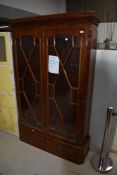 An early 20th Century mahogany bookcase having astral glazed doors and low drawer base