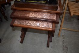 A vintage nest of three teak framed copper top table