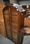 An early 20th Century oak bookcase, having arch top