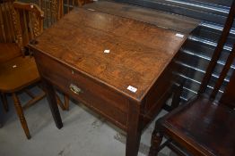 A 19th Century oak clerks or shop desk, having slope top with three internal and one frieze