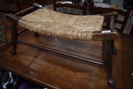 A traditional stained frame woolwinder stool having seagrass seat