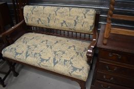 A Victorian mahogany settee having part spindle back, scroll arm and later upholstery, width approx.