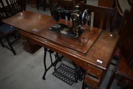 A Victorian treadle sewing machine having cast base and mahogany case