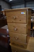 A modern pine three drawer bedside chest