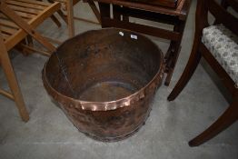 An antique copper log basket or planter, planished style finish