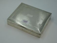 A silver cigar box of rectangular form having engine turned decoration and plain cartouche,