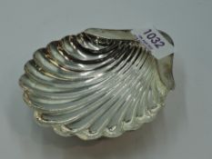 A small silver scallop shell butter dish on trefoil bun feet, London 1915, Monoah Rhodes & Sons Ltd,