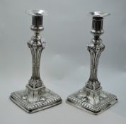 A pair of Georgian silver candle sticks having extensive decoration including rams head and hoof
