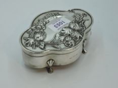 A silver dressing table trinket box of shaped oval form having Art Nouveau style repousse floral