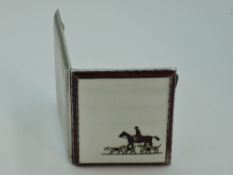 A silver cigarette case having enamelled hunting scene to white background to front and engine