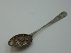 A Georgian silver berry spoon having bright cut decoration and embossed and frilled bowl, London