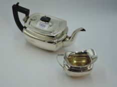 A silver breakfast teapot and cream jug of plain ovoid form with hard wood architectural handle,