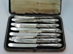 A cased set of side knives having HM silver moulded handles, and six butter knives having moulded