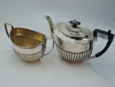 A silver teapot and sugar bowl having gadrooned decoration and architectural handles, Sheffield
