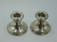 A pair of silver candle sticks of plain circular squat form, Birmingham 1957, WI Broadway & Co,