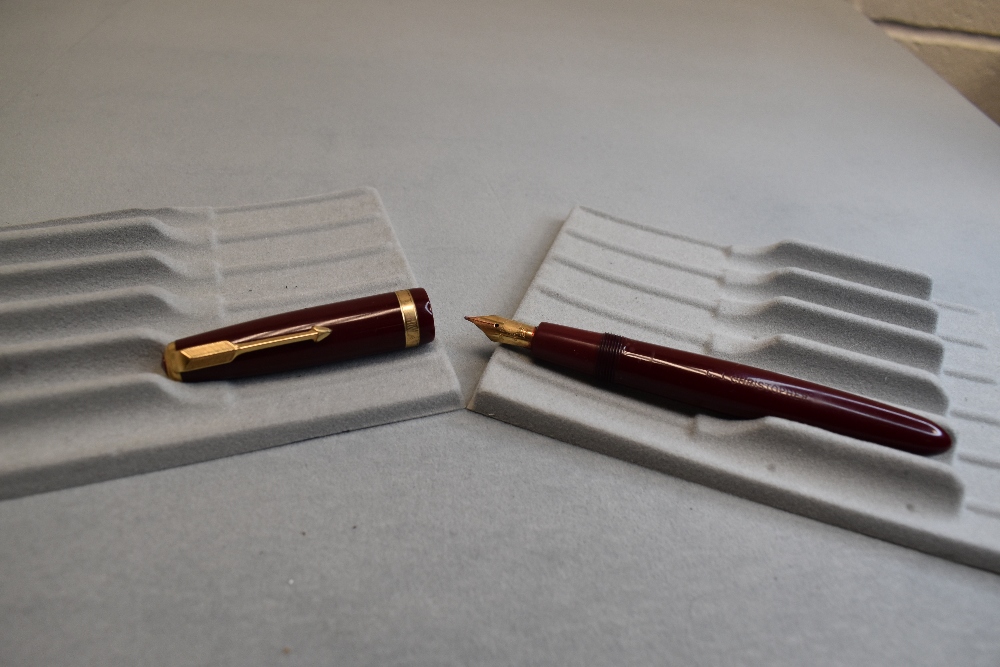 A Parker Duofold fountain pen in burgundy with broad decorative band to the cap and having a