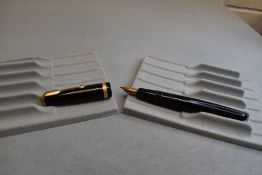 A Parker Duofold fountain pen in black with broad decorative band to the cap and having a Parker