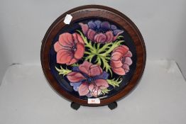 A Moorcroft Pottery 'Clematis' Pattern plate, tube-lined with flowers against a cobalt grounds,