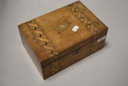 A late 19th century walnut sewing box, of hinged rectangular form with bands of geometric inlay,