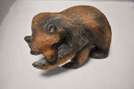 A large carved and stained softwood 'Blackforest' style bear, hunting salmon 15cm x 25cm