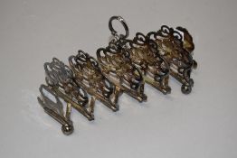 An Edwardian concertina style fold out toast rack silver plated with pierced and floral design