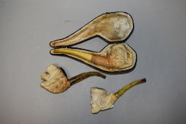 A group of three 19th century style meerschaum pipes, decorated as a lion mask, eagles claw and