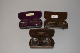 Two pairs of early 20th century yellow metal and tortoiseshell spectacles, together with a pair of