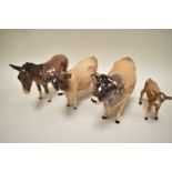 A Beswick Jersey cow family including bull calf and cow along with similar donkey