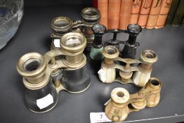 A collection of mixed antique opera glasses and binoculars.