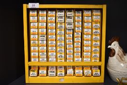 A collection of mixed NGK spark plugs in boxes in display rack.