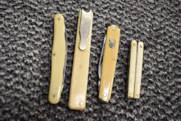A Victorian ivory pen nibber or quill cutter and three pen knives.