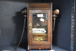 A 19th century glass fronted lockable smokers cabinet having internal draw and pipe racks to sides