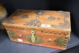 An Indian wooden jewellery box having embossed metal detailing,two handles to sides and red velvet