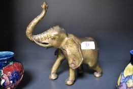 An African heavy cast-brass elephant figure, modelled as if trumpeting, 19cm.