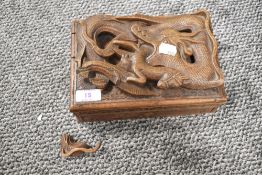 A carved wooden box having compartmental interior of Japanese style depicting dragon consuming