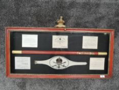 A framed and glazed display of 1911 King George V Coronation Gold Staff Officers Staff, Arm Band an