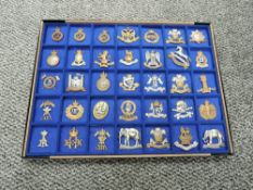 A display tray of Thirty Five metal Military Cap Badges including The 4th Royal Irish D.Guard, Kings