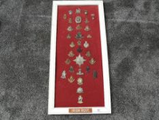 A framed display of Military Cap Badges for Irish Regiments including Inniskilling, Royal Munster,