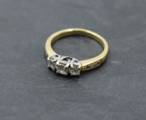 A diamond trilogy ring, total approx 0.5ct in a stylised claw set mount to diamond set shoulders