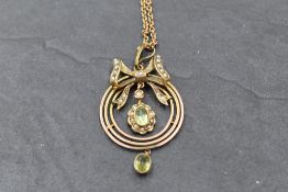 A yellow metal Edwardian pendant of circular form stamped 9ct having bow detail with seed pearl
