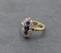 A sapphire dress ring having a vertical trio of sapphires within an oval border of old cut