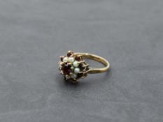 A garnet and seed pearl triple cluster dress ring in a claw set mount on a yellow metal loop,