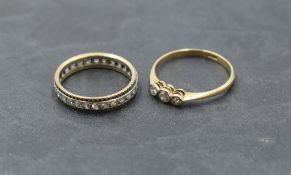 A diamond trilogy ring, total approx 0.15ct in collared mounts on a yellow metal loop stamped