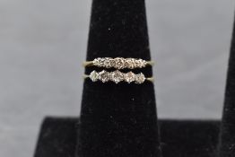 Two five stone diamond dress rings of traditional form on yellow metal loops stamped 18ct, size
