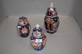 Three 19th century Japanese porcelain lidded jars having a traditional imari design