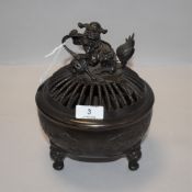 A late 19th century Chinese bronze temple censer having pierced rope lid adorned with dog of fu