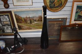 A large floor standing black art glass bottle